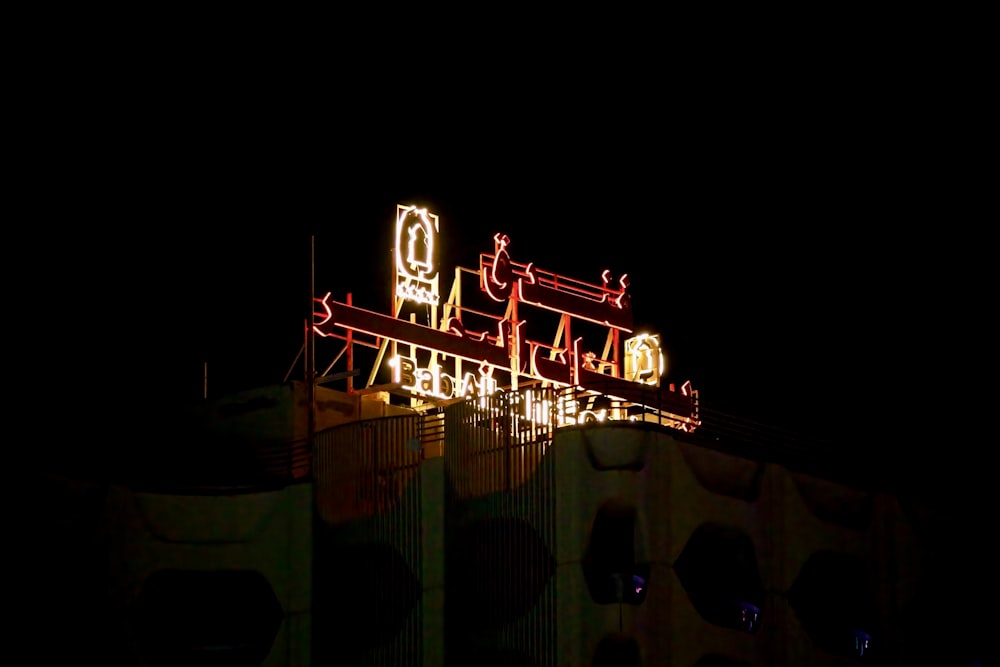 a building lit up at night with a clock on top