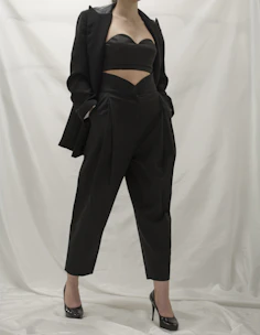 A sleek, modern outfit featuring a chic western dress styled with minimalist accessories on a dark background.