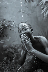 Close-up of a joyful child playing in the rain in a small village.