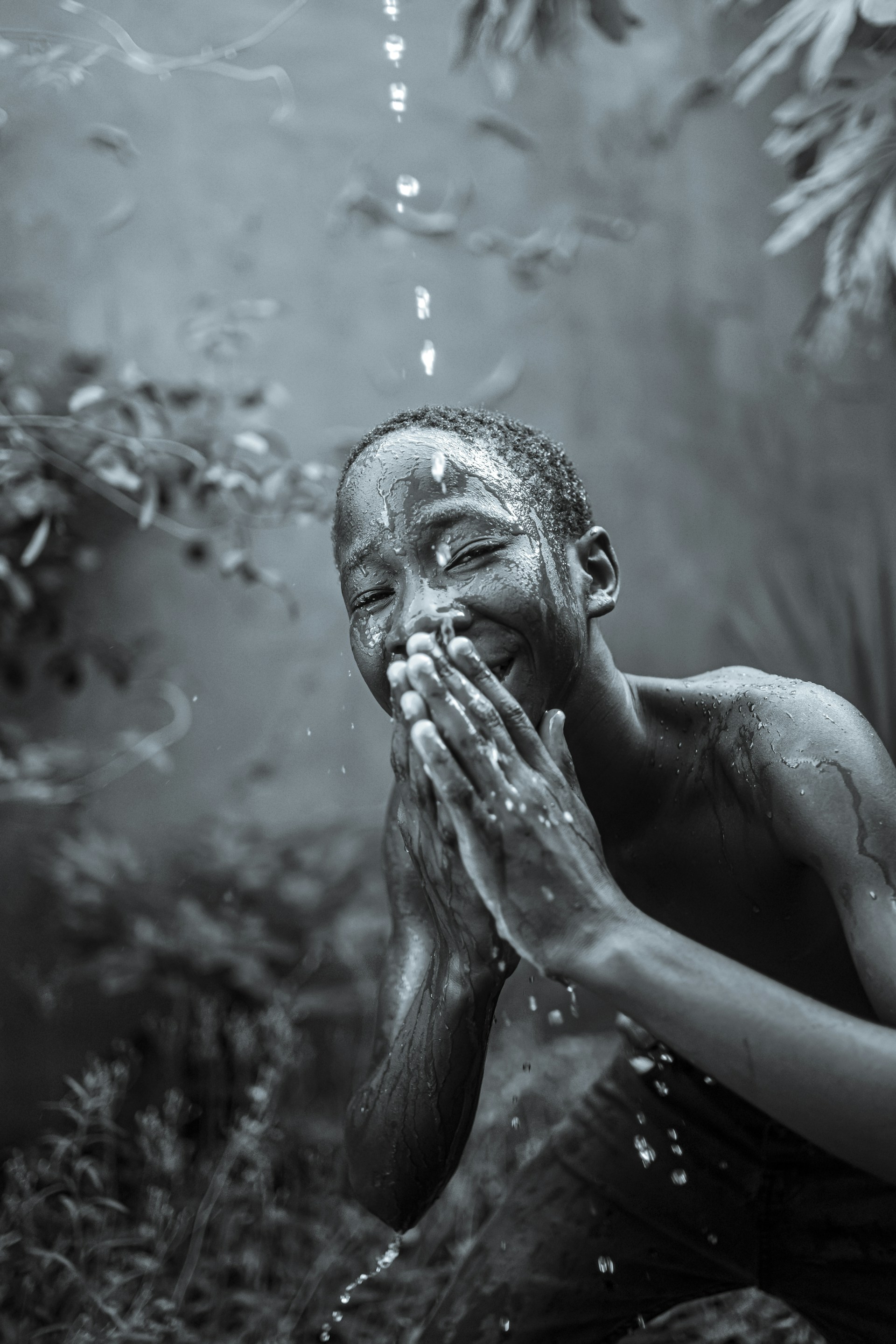 a black and white photo of a man covered in water