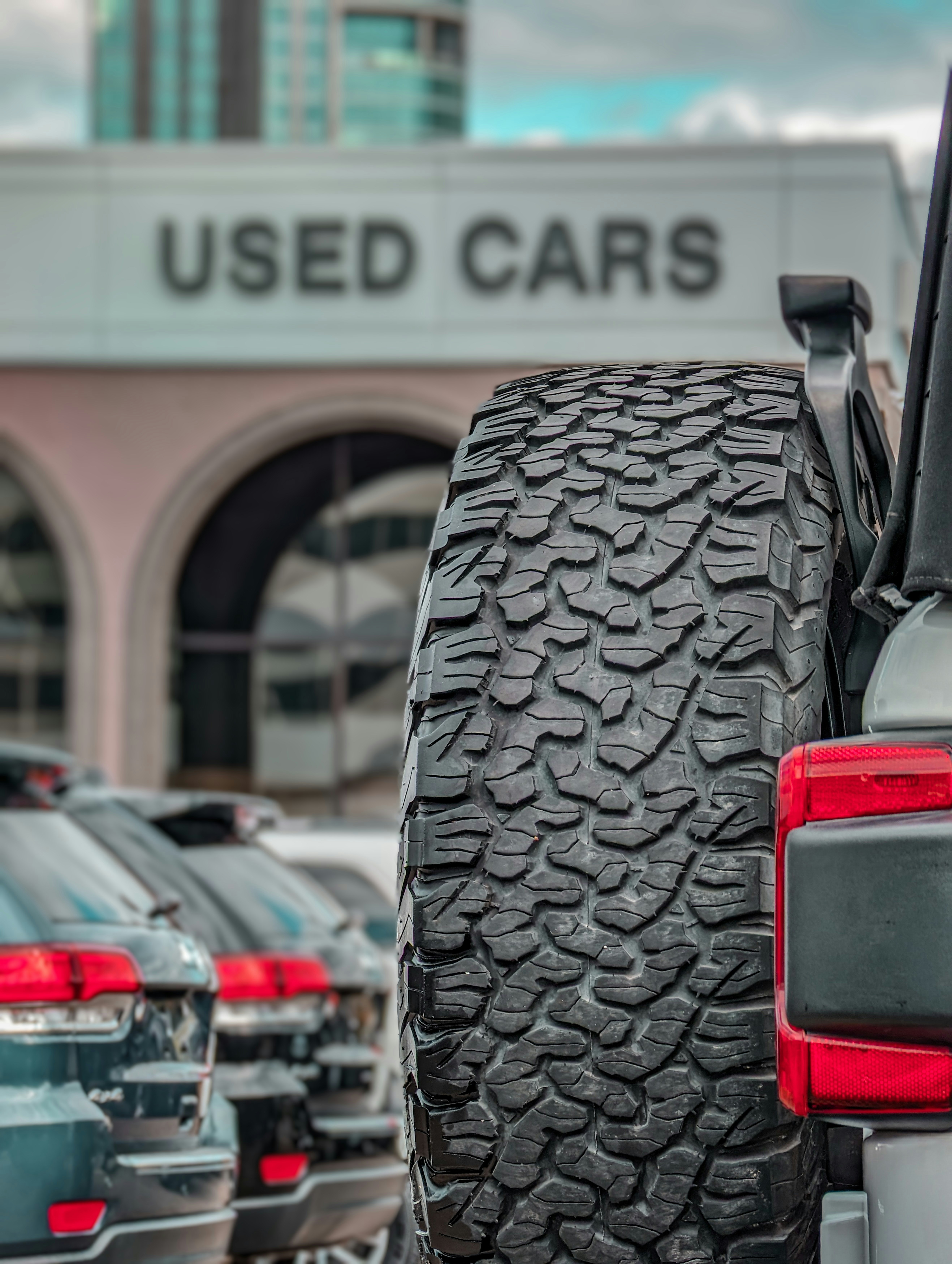 a row of cars parked in front of a used car dealership