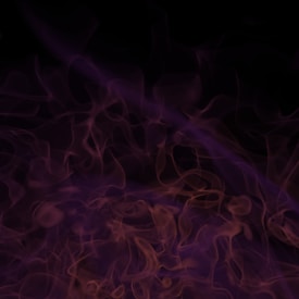 Swirling patterns of purplish smoke or mist against a dark background, creating a mysterious and ethereal effect.