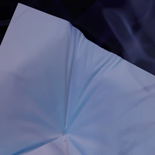 Elegant blue sugar paper background with a neatly folded white cotton shirt.