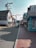 A quaint street lined with shops featuring outdoor signage, including a large ice cream cone. American flags and a Budweiser sign add to the small-town atmosphere. The street is busy with pedestrians and a bicycle cart labeled 'bwell' in the center.
