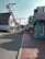 A quaint street lined with shops featuring outdoor signage, including a large ice cream cone. American flags and a Budweiser sign add to the small-town atmosphere. The street is busy with pedestrians and a bicycle cart labeled 'bwell' in the center.