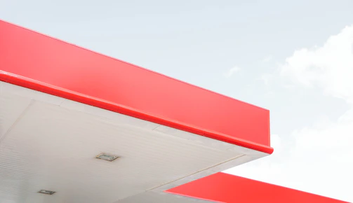 A stunning exterior shot of a modern minimalist building with clean lines and deep red accents.