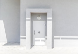 Architect examining detailed door designs in a bright, minimalist workspace.