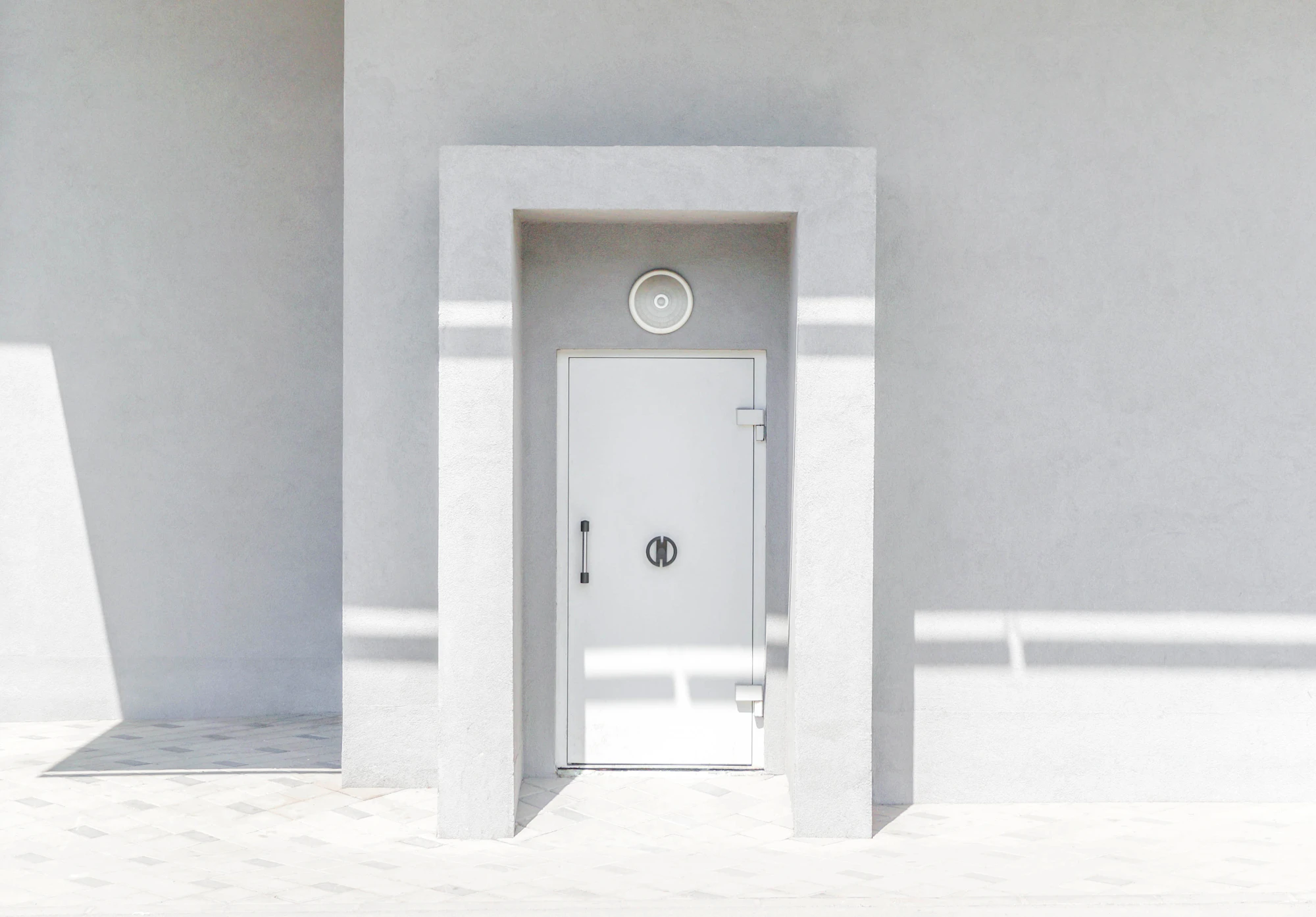 A bright white interior door open in a minimalist room