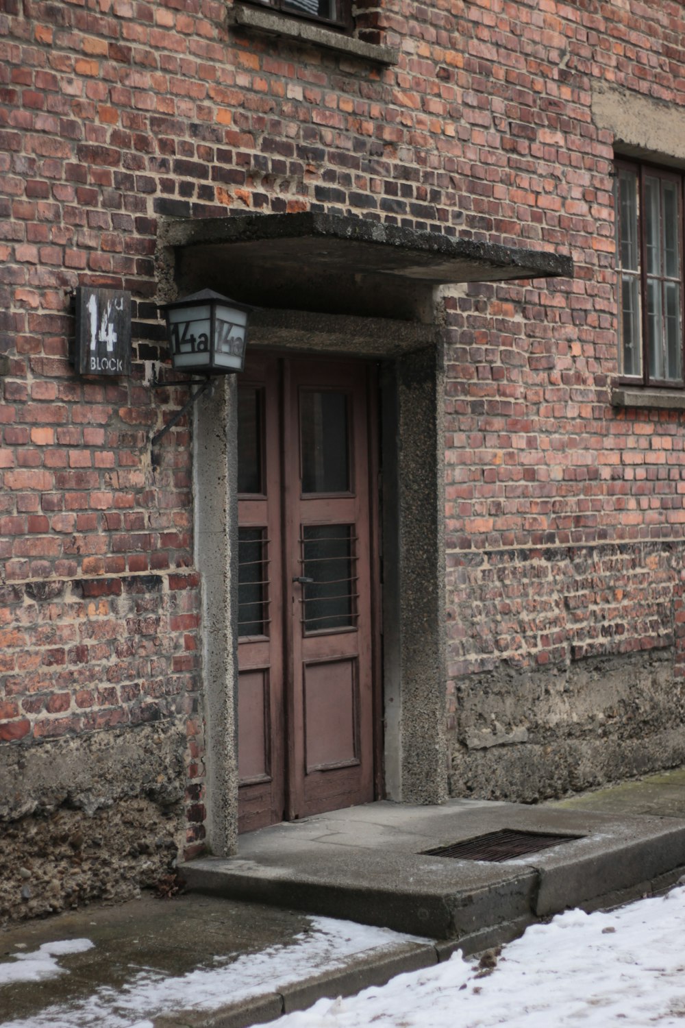 a brick building with a red door and window