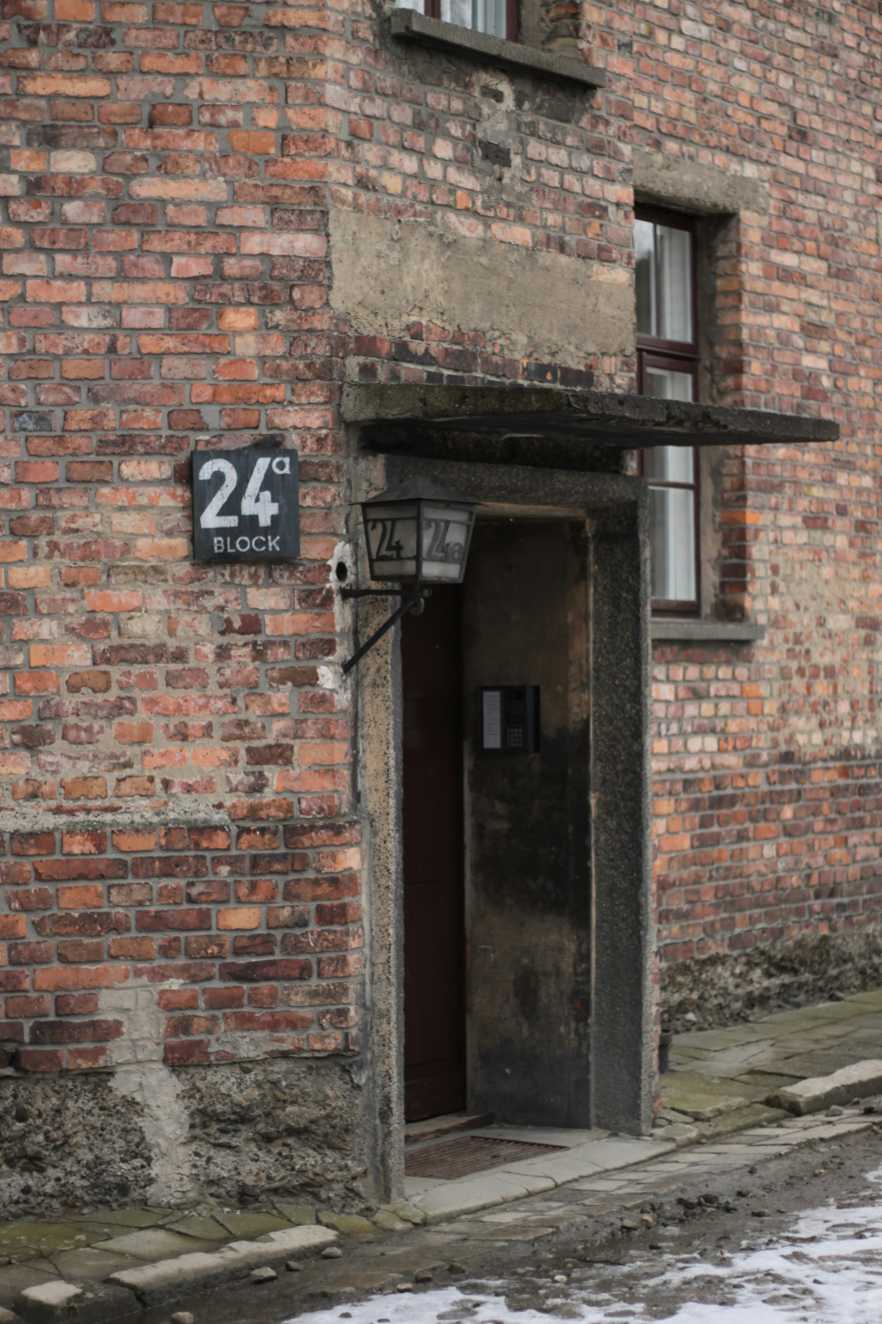 a red fire hydrant sitting in front of a brick building