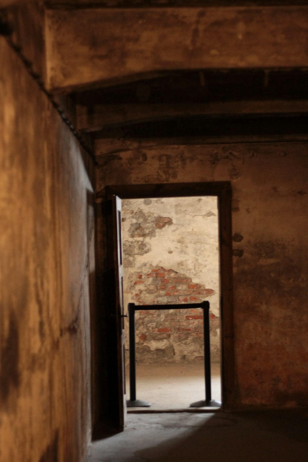 an open door leading to a room with a brick wall