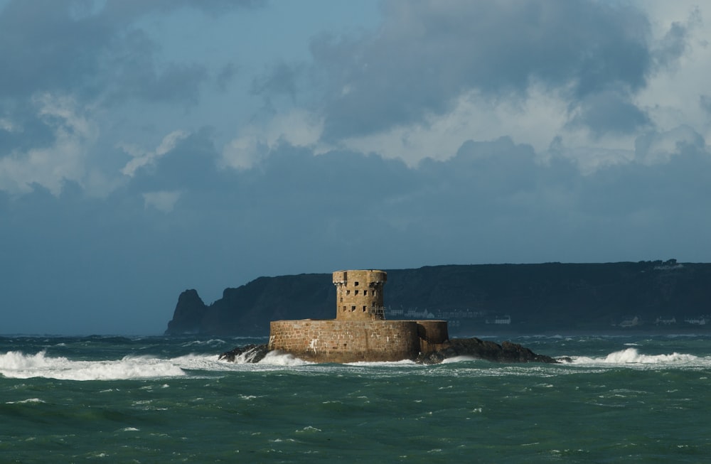 Un castello seduto in cima a una roccia in mezzo all'oceano