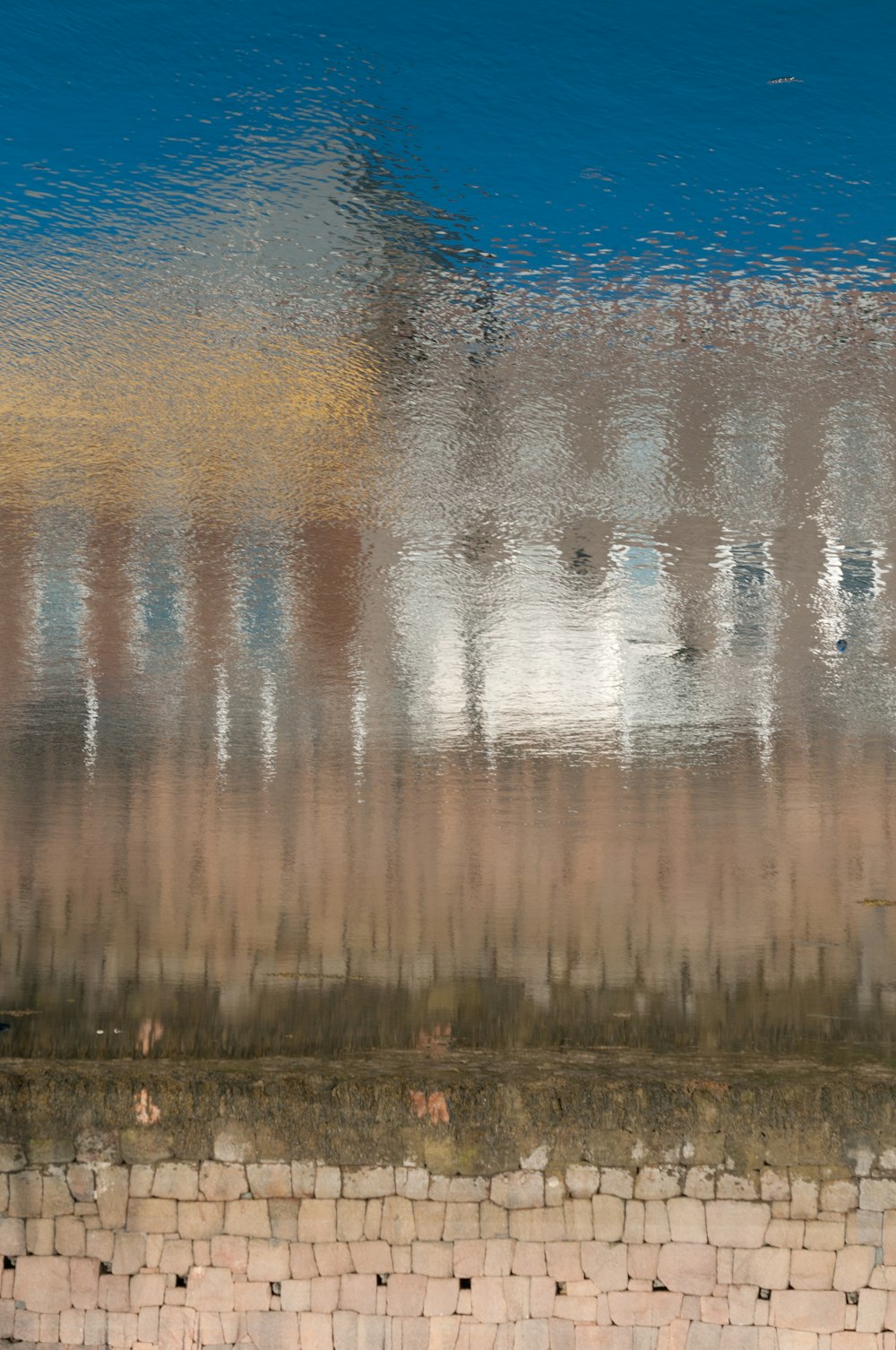 a reflection of a building in a puddle of water