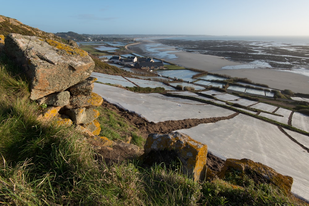 a snow covered field with a rock wall in the foreground