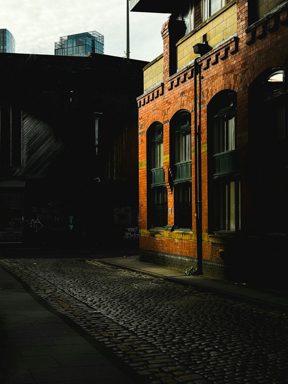 a brick street with a clock tower in the background