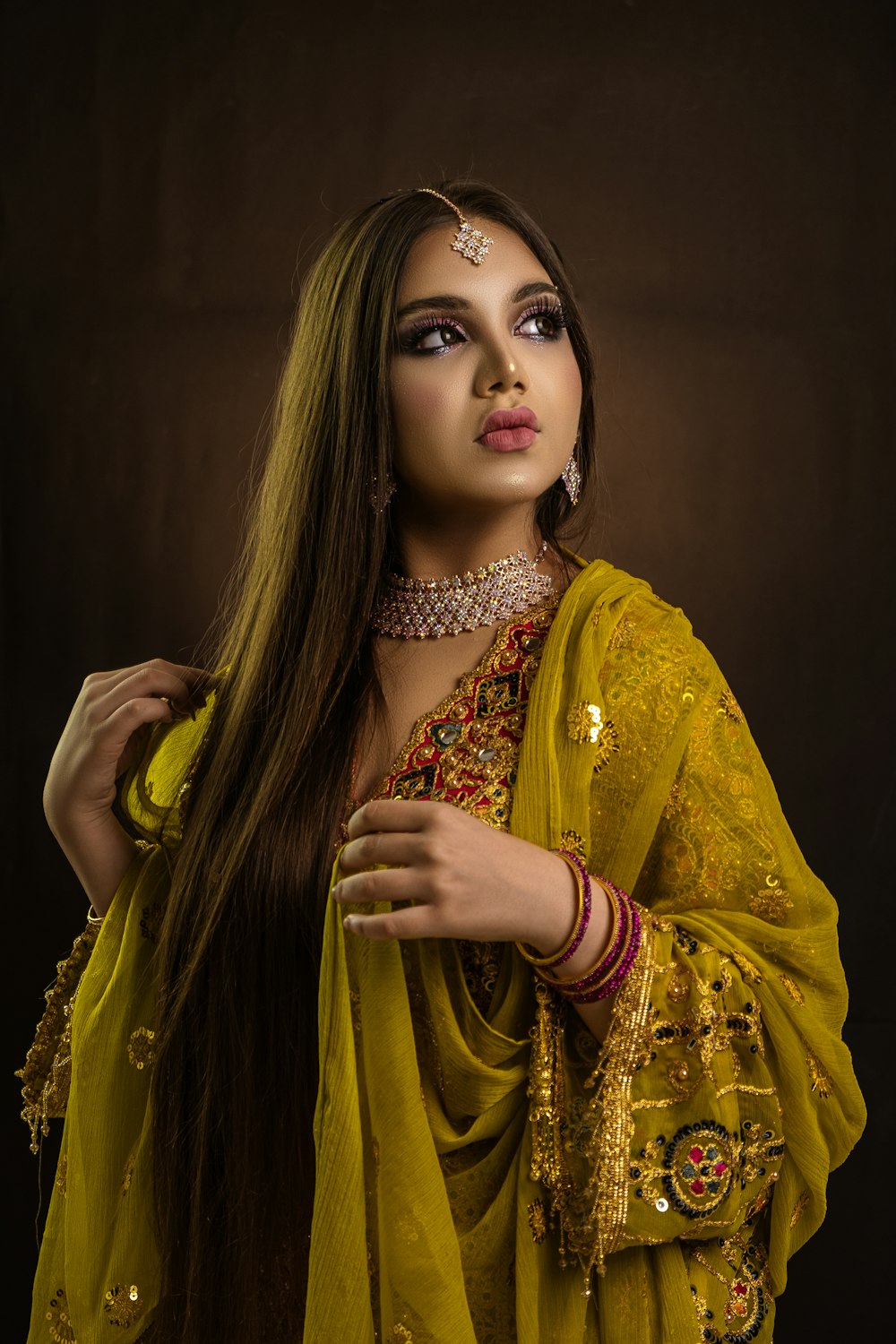 a woman with long hair wearing a yellow outfit