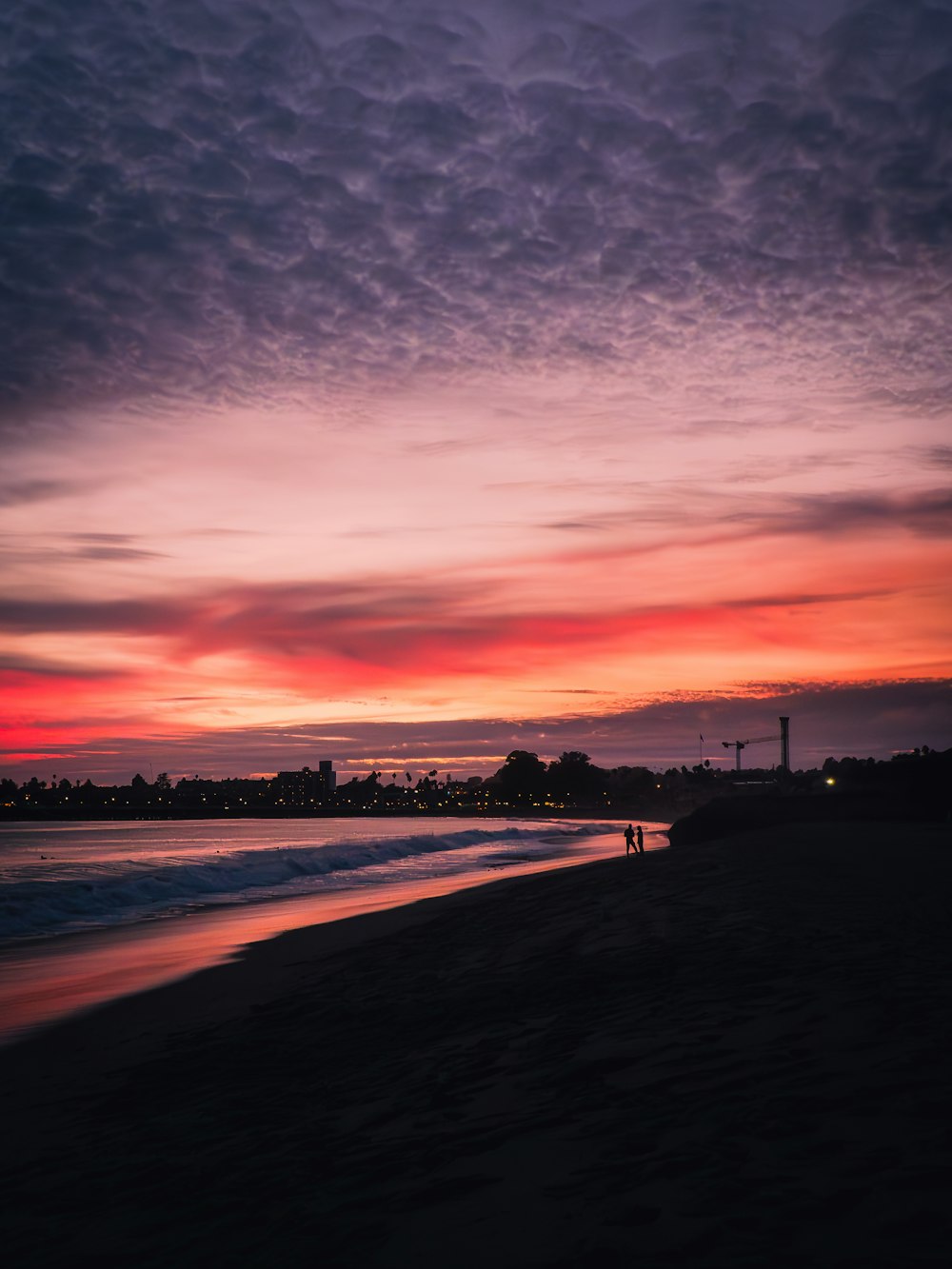 a person standing on a beach at sunset