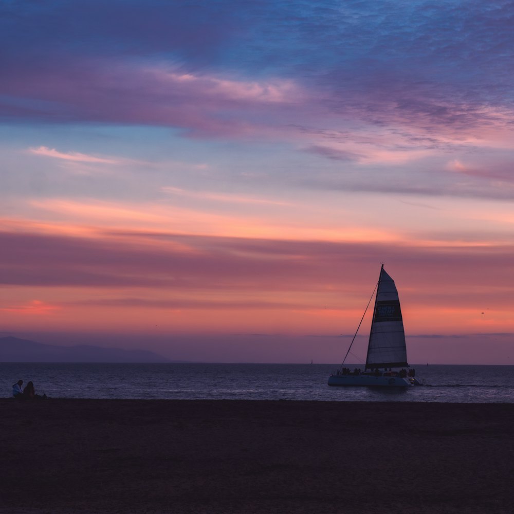 a sailboat in the ocean at sunset