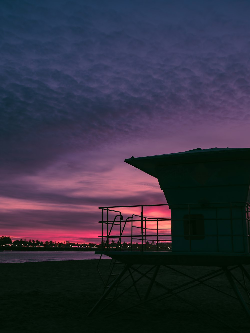 a lifeguard tower sitting on top of a sandy beach