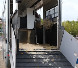 a horse trailer with hay inside of it