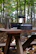 A foldable outdoor camping table set up beside a forest campsite.
