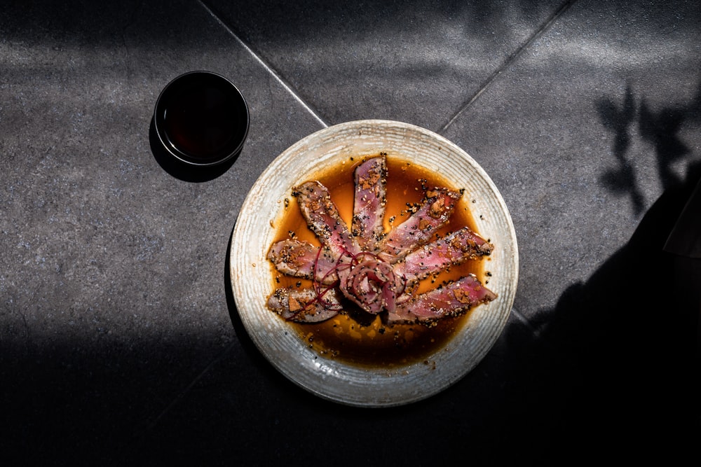 a plate of food on a table next to a glass of wine