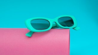 a pair of sunglasses sitting on top of a pink box