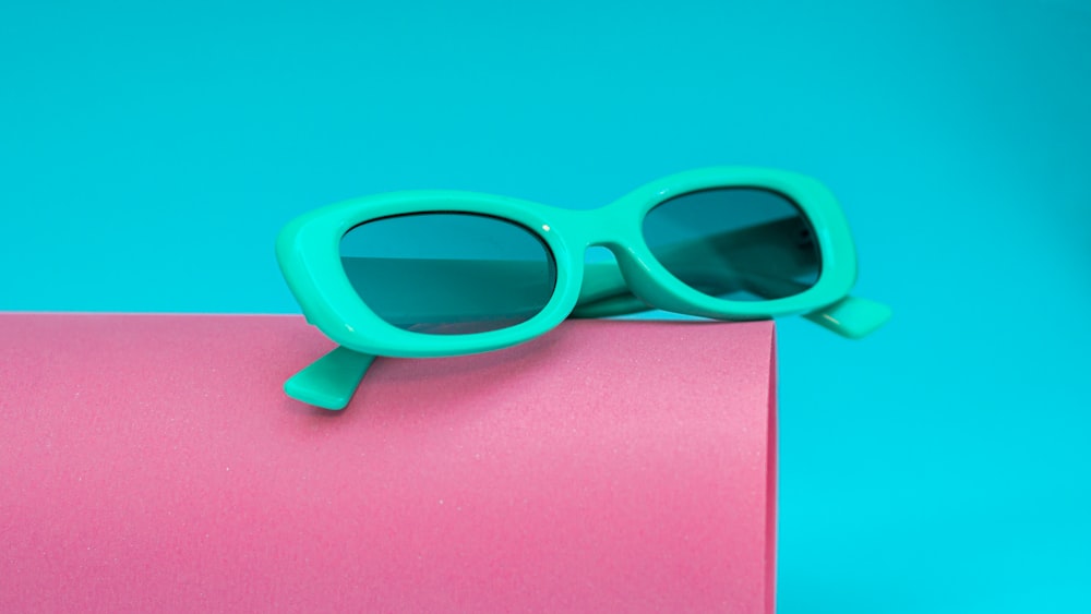 a pair of sunglasses sitting on top of a pink box
