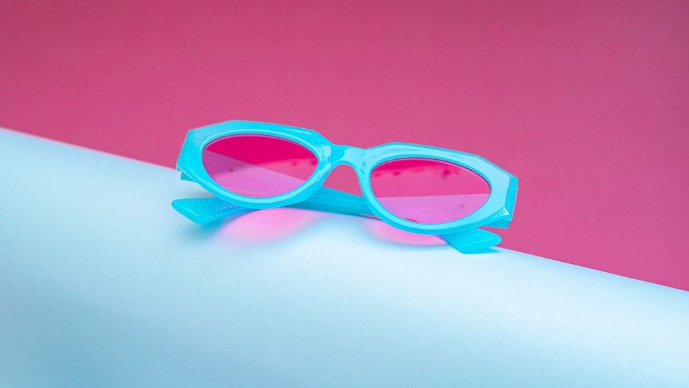 a pair of blue sunglasses sitting on top of a table