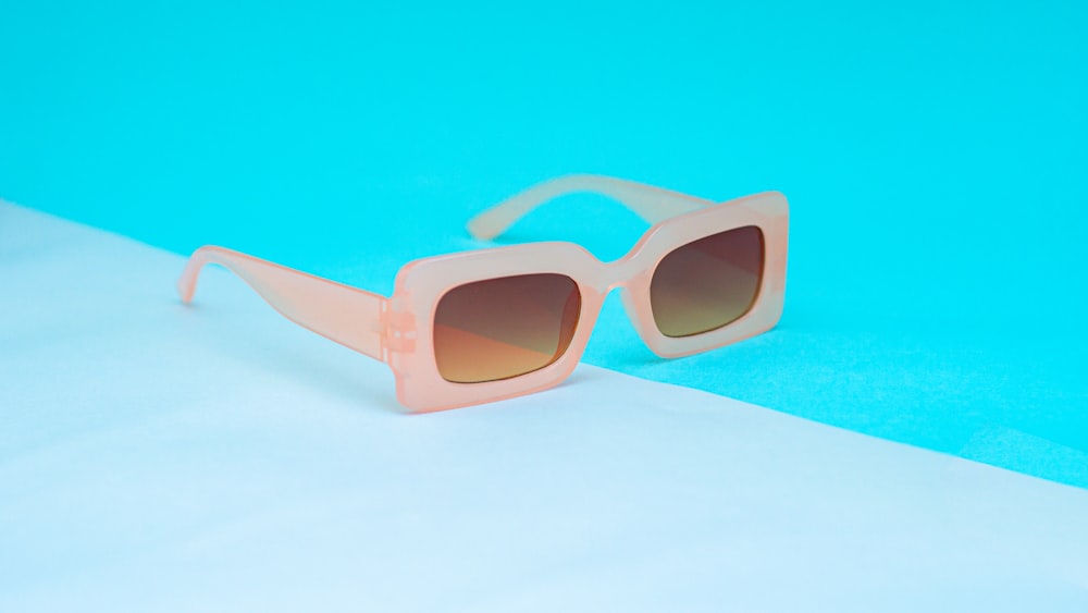 un par de gafas de sol colocadas sobre una superficie azul