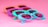 Several pairs of colorful sunglasses are laid out against a bright pink background. The frames of the sunglasses are in playful pastel shades, including purple, turquoise, and peach, giving off a retro and summer vibe.