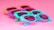 Several pairs of colorful sunglasses are laid out against a bright pink background. The frames of the sunglasses are in playful pastel shades, including purple, turquoise, and peach, giving off a retro and summer vibe.
