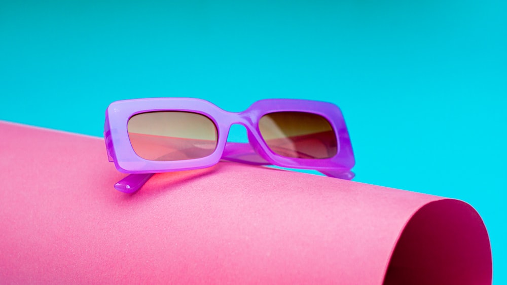 un paio di occhiali da sole seduti sopra un tubo rosa