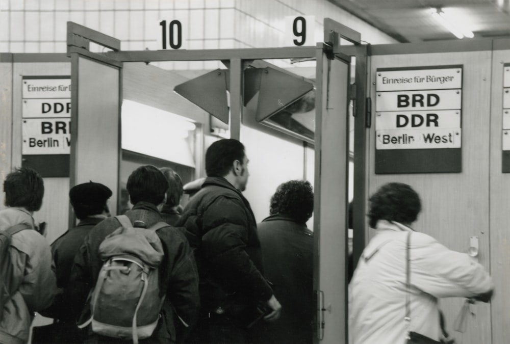 a black and white photo of a group of people on a subway