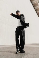 a man in black pants and a white t - shirt standing in front of a