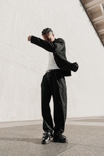 a man in black pants and a white t - shirt standing in front of a