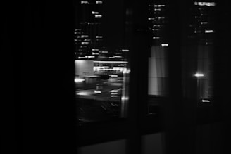 A blurred cityscape viewed through a rain-speckled window.