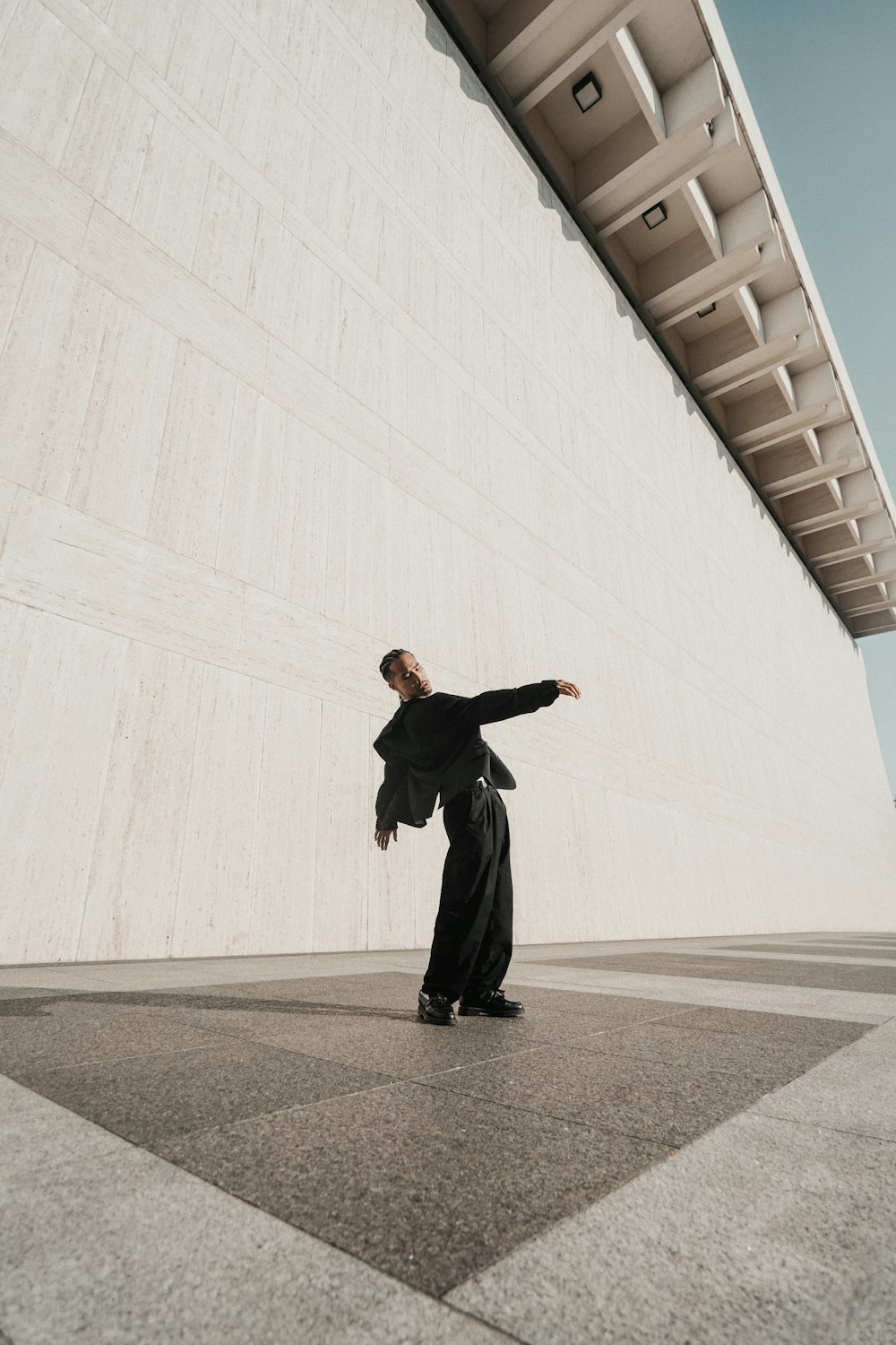 a man standing in front of a white wall