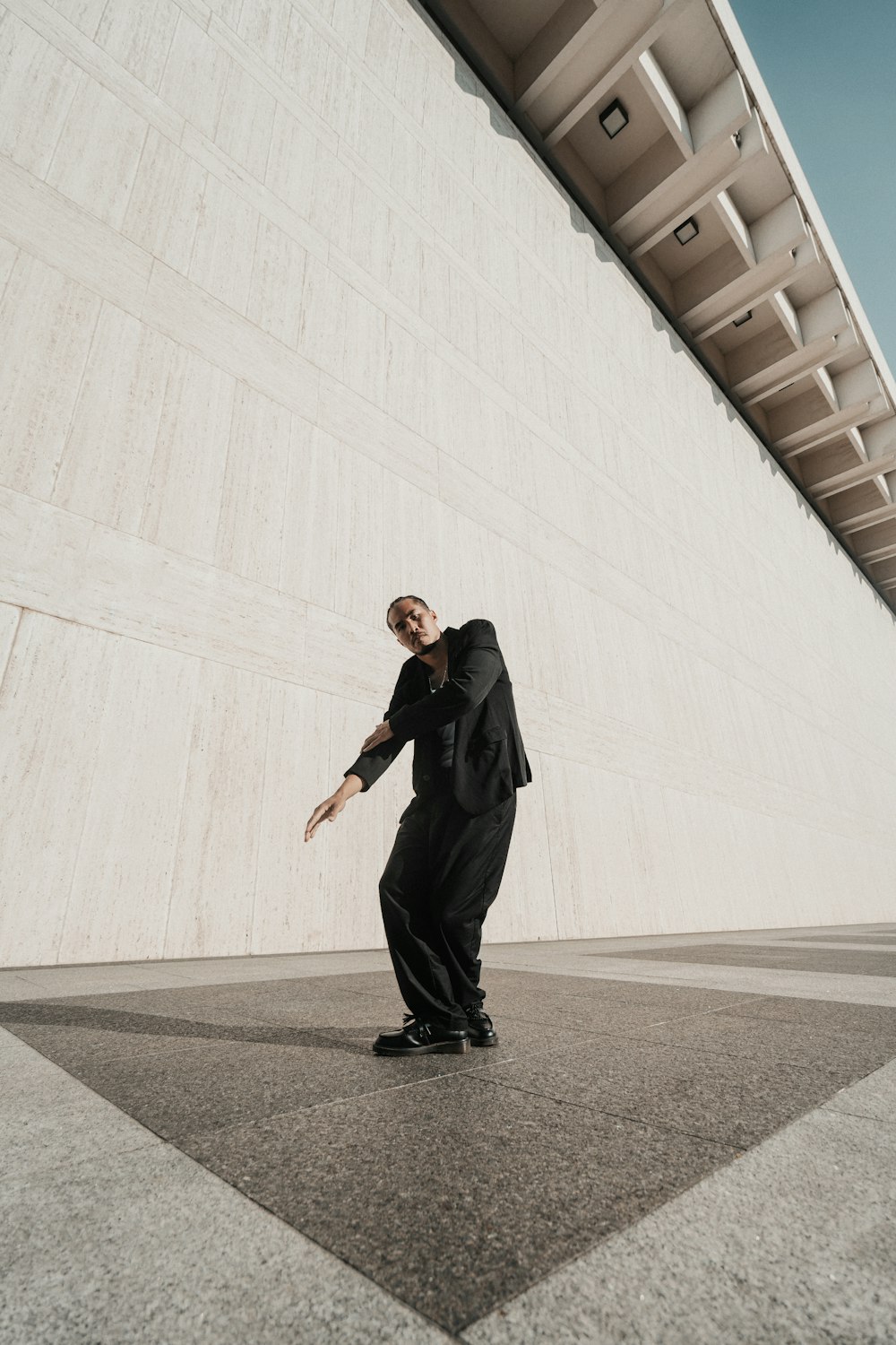 un uomo in giacca e cravatta in piedi davanti a un edificio