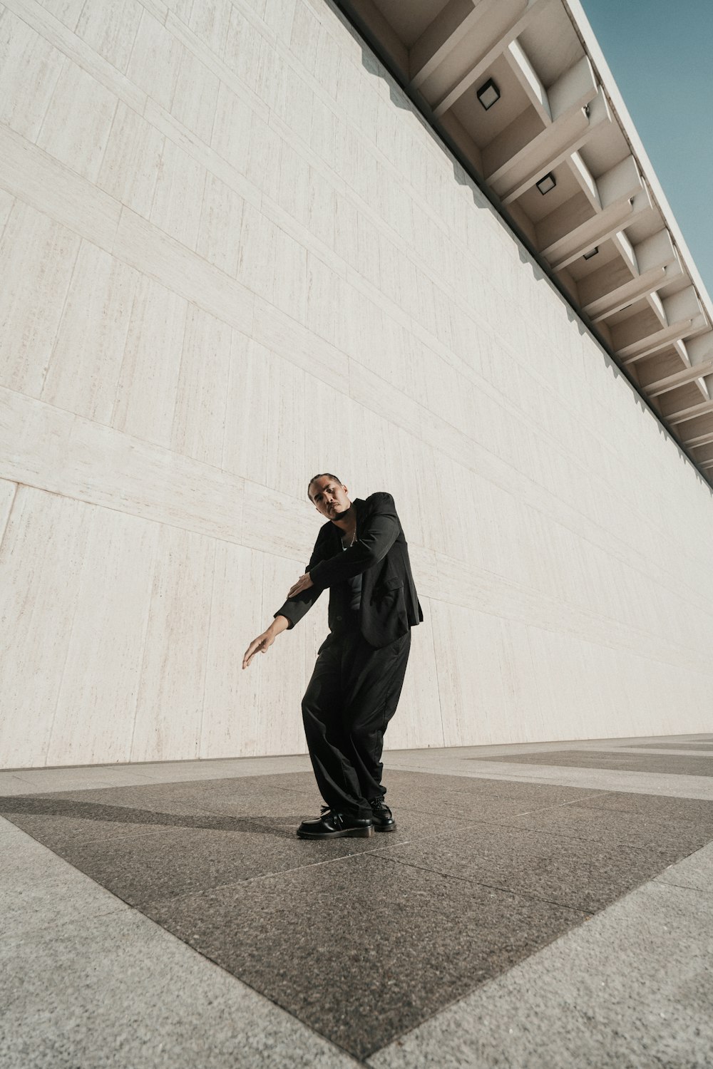 a man in a suit standing in front of a building