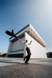 a man riding a skateboard next to a tall building