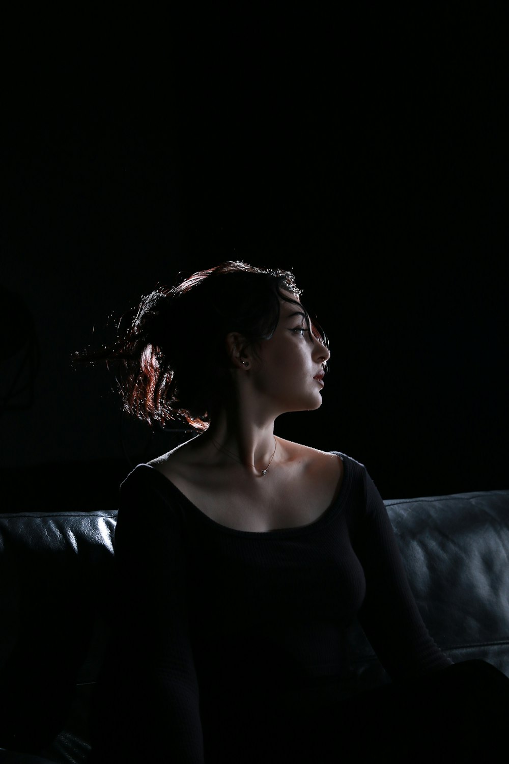 a woman sitting on a couch in the dark