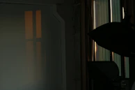 Studio speakers casting soft light in a cozy room filled with acoustic panels.