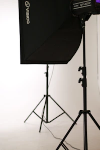 A sleek photography setup with softbox lights casting warm glows on a minimalist black backdrop.