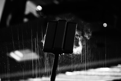 Black-and-white photo of a noir-inspired street corner with old-fashioned lampposts and rain-soaked pavement.