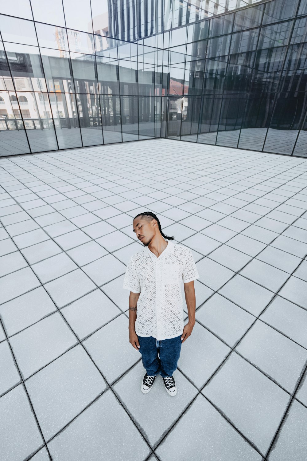 a man standing in front of a glass building