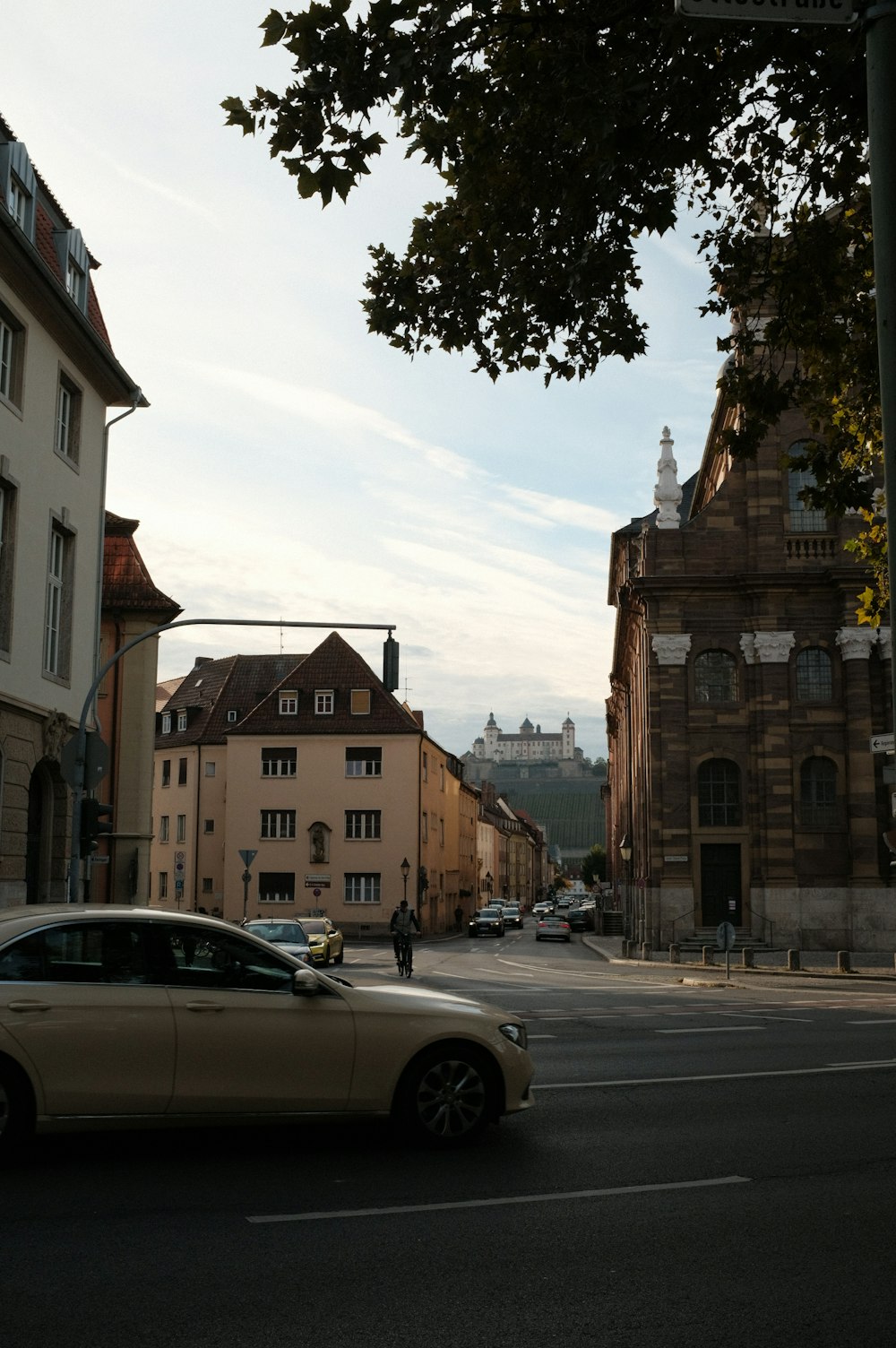 a car driving down a street next to tall buildings