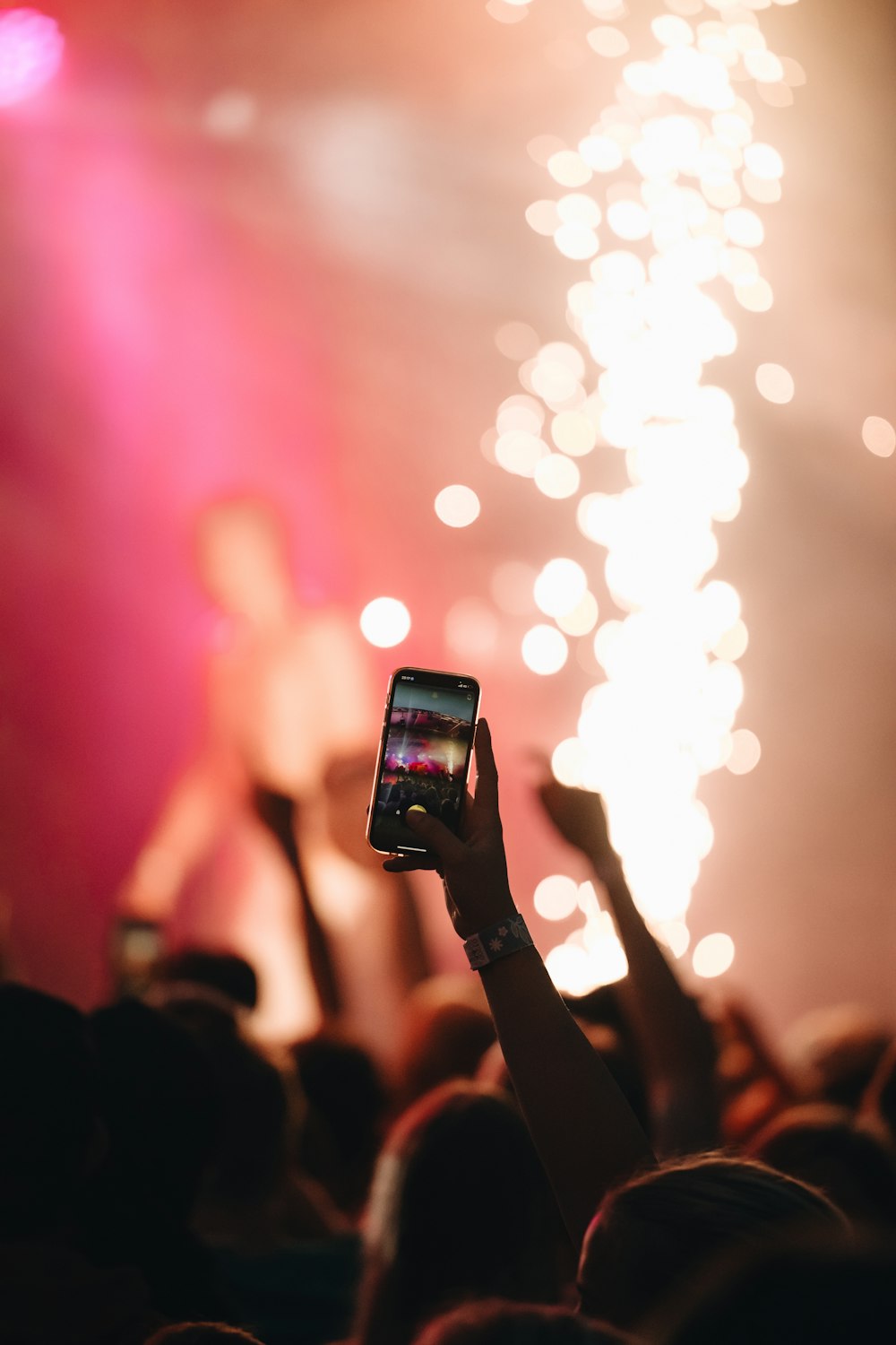 a person taking a picture of fireworks with a cell phone