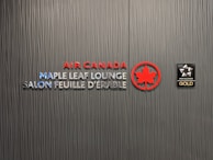 A textured wall featuring the logos and text for Air Canada Maple Leaf Lounge and Star Alliance Gold. The text includes bilingual English and French, with the Air Canada logo prominently displayed in red next to a stylized maple leaf.
