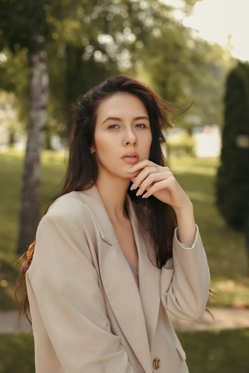 a woman in a beige suit posing for a picture